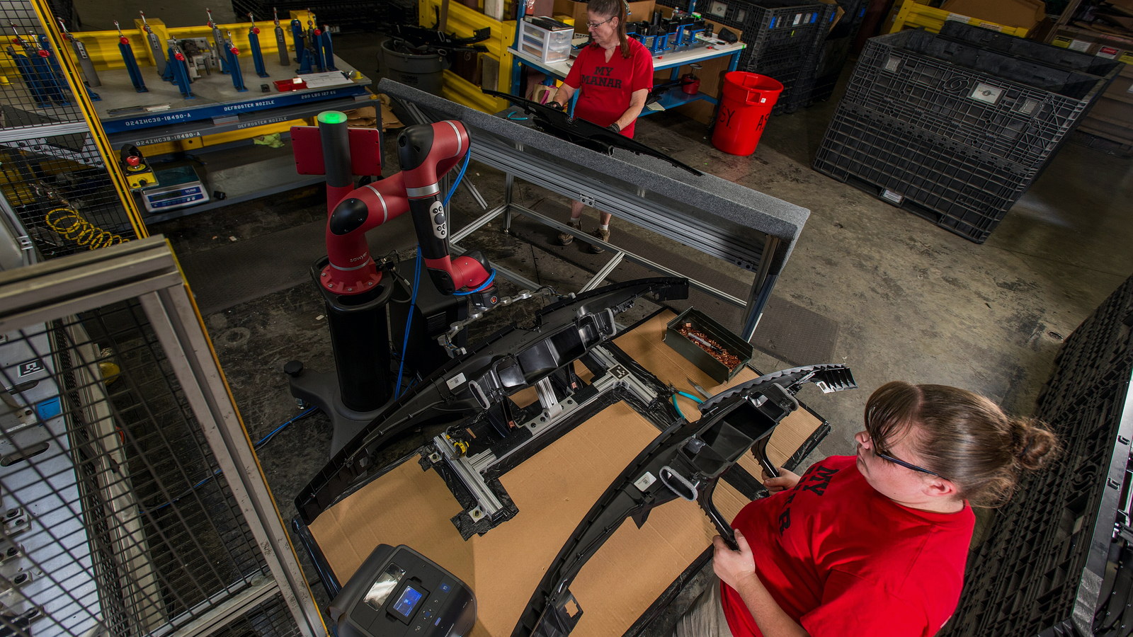 Collaborative robot operating alongside engineers on a production line